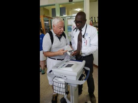 Ernie Sandona (left), biomedical engineer and Issa Trust Foundation volunteer, demonstrates some of the modern features of the state-of-the art ECG machine to Dr Vincent Riley, cardiologist.